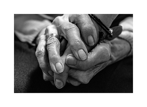 Ein Händedruck zwischen Enkelin und Großmutter im Altenheim