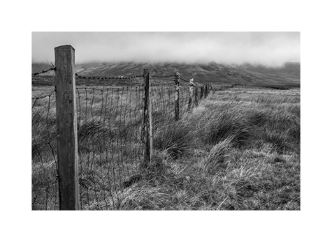 Ein Zaun führt in ein einsames Moor in Irland